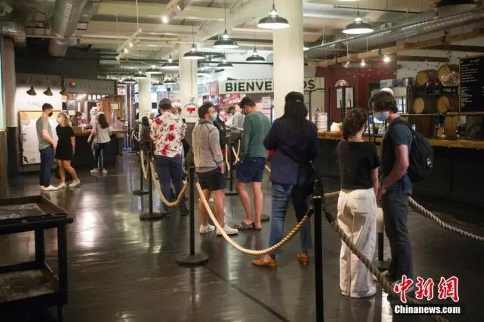 资料图:当地时间5月25日,顾客在美国纽约切尔西市场一家餐厅排队购买餐食。自5月下旬纽约州博物馆、电影院、餐厅、零售业等商业和文化场所的客容量限制全面解除后,纽约著名的切尔西市场客流逐渐恢复。 <a target='_blank' href='http://www.chinanews.com/'>中新社</a>记者 廖攀 摄
